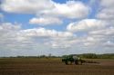 Tractor spraying herbicide on tilled crop soil in Lapeer County, Michigan, USA.