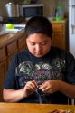 Native Pueblo boy crafting dreamcatchers in San Felipe Pueblo, New Mexico, USA.