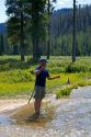 Fisherman catching a trout at Bull Trout Lake located in the Boise National Forest near Lowman, Idaho, USA.