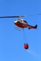 Helicopter with water bucket performing aerial firefighting on a wildfire near Boise, Idaho, USA.