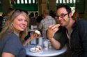 A couple eating beignets at Cafe Du Monde in the French Quarter of New Orleans, Louisiana, USA.