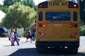 School bus stop with children crossing the street in Notus, Idaho, USA.