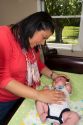 Hispanic mother with infant son on a changing table in Boise, Idaho, USA. MR