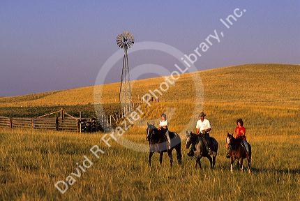 A ranch family riding horses on the prairie in Wyoming.