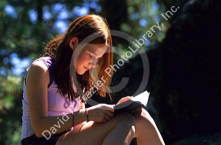 A teenage girl reading a book. MR