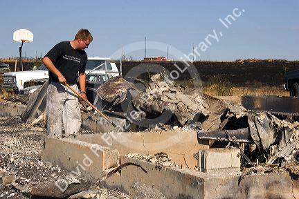 Victim of a house fire sifts through the ashes near Mountain Home, Idaho.