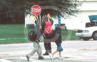School crossing guard with children walking on crosswalk. MR