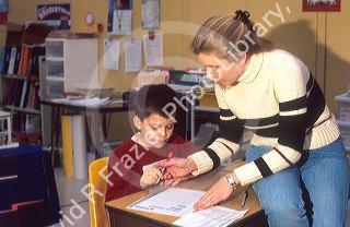 Elementary school teacher helping a student in her classroom. MR