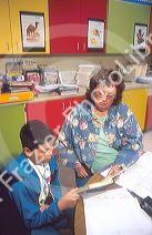 Elementary school teacher helping a male hispanic student in the classroom. MR