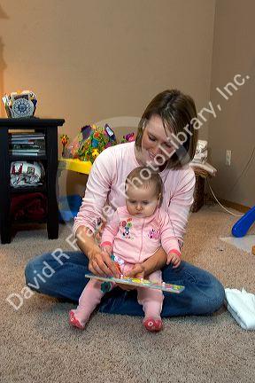 A mother and her infant child playing with toys. MR