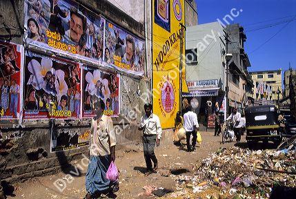 A street scene with movie posters on a wall in Bangalore, India.