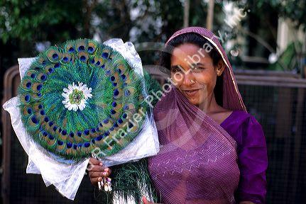 A street vendor selling peacock feather fans in Bombay, India.