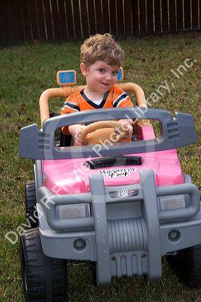 Three year old boy riding in a battery powered toy car. MR