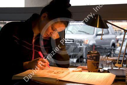 Female college student studying at a coffee shop in Boise, Idaho. MR