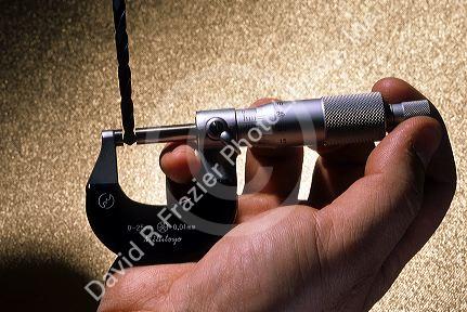 Micrometer measuring a drill bit.