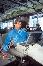Man using a laptop computer at airport waiting area.