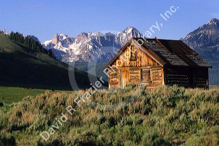 A log cabin and the Sawtooth Mountains in Stanley, Idaho.