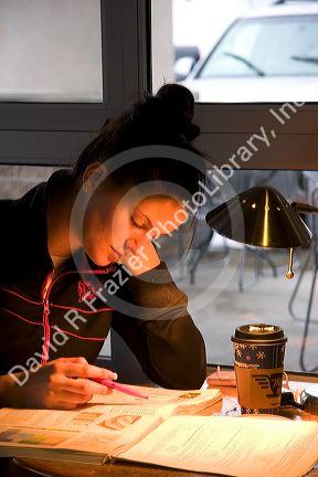 Female college student studying at a coffee shop in Boise, Idaho. MR