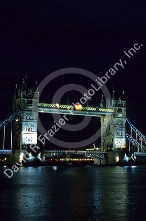 The Tower Bridge across the Thames River at night in London, England.