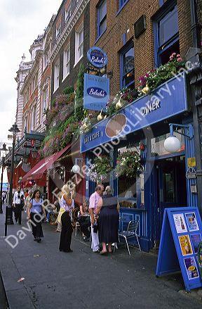 People stand in front of pub's in the Paddington area of London, England.