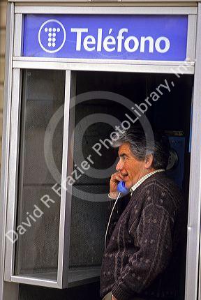 A man using a public telephone in Spain.