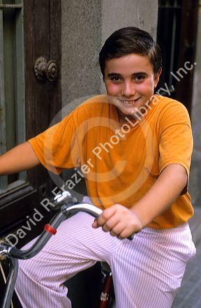 A spanish boy riding a bicycle in Spain.