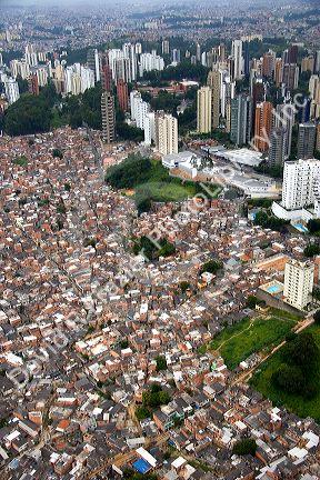 Aerial view of crowded favela housing contrasts with modern apartment buildings in Sao Paulo, Brazil.