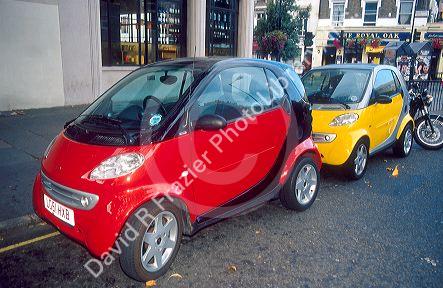 Smart cars on London street in England.  These fuel-efficient cars are made by Mercedes and popular throughout Europe.