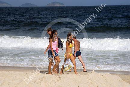 Visitors walk on the Copacabana Beach in Rio de Janeiro, Brazil.