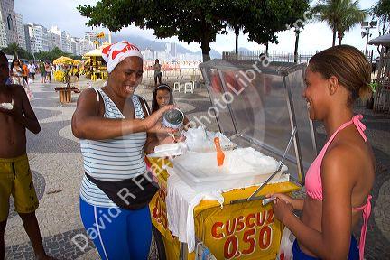 A street vendor selling cuscuz, a coconut snack, at the Copacabana Beach in Rio de Janiero, Brazil.