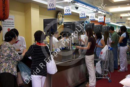 Customers at a supermarket checkout in the Liberdade asian section of Sao Paulo, Brazil.