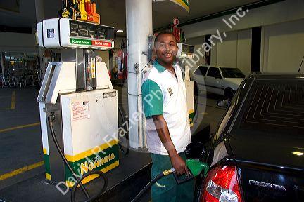Attendant at a gas station pumping alcohol into a car in Sao Paulo, Brazil.