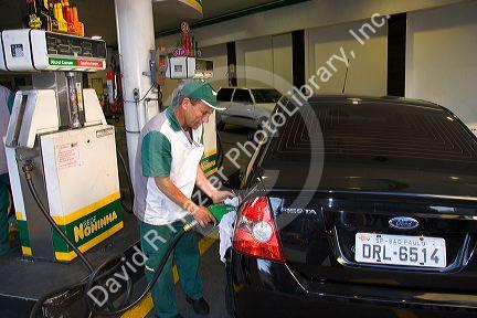 Attendant at a gas station pumping alcohol into a car in Sao Paulo, Brazil.