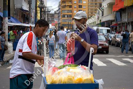 A street vendor selling slices of watermelon and mango in Sao Paulo, Brazil.