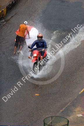 Motorcylce and street vendor on a rain flooded street in Manaus, Brazil.