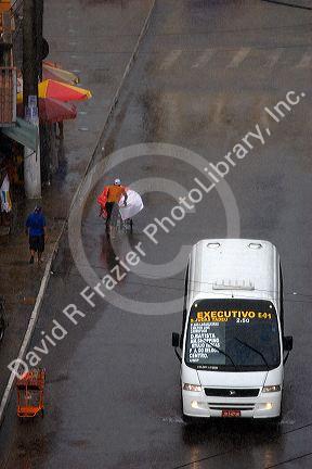 Van and street vendor on a rain flooded street in Manaus, Brazil.