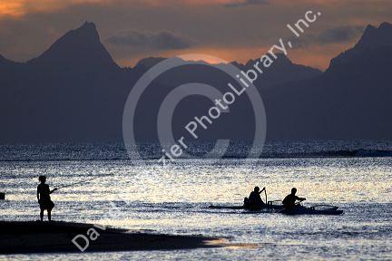 Fishing and outrigger canoeing at sunset on the island of Tahiti.