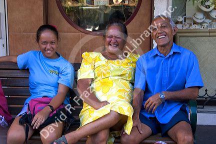 Tahitians sit on a park bench in Papeete on the island of Tahiti.