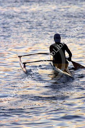 Outrigger canoeing at sunset off the island of Tahiti.