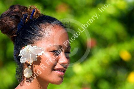 Tahitian woman wearing a tropical flower in her hair on the island of Moorea.