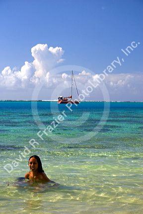 Tahitian woman swimming topless in the lagoon on the island of Moorea. MR