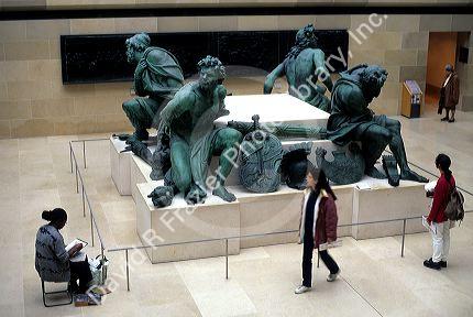 Artist and sculpture at The Louvre in Paris, France.