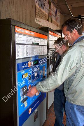 Men purchasing metro cards from a ticket vending machine for the Metrorail System in Washington, D.C.