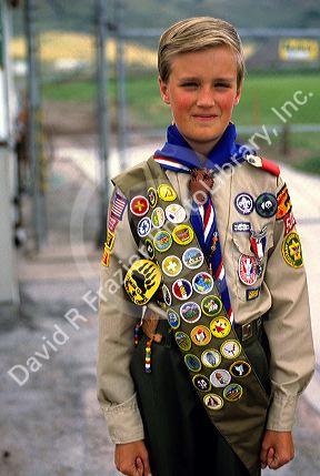 Boy scout in uniform with sash of badges.