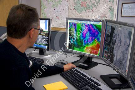 Meteorologist looking at weather maps with satellite data on computer screens at the National Weather Service in Boise, Idaho.