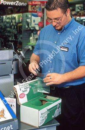 Radio Shack employee using a battery disposal unit.