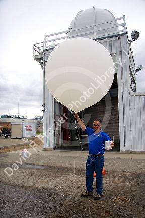 Meteorologist launching a weather balloon with a radiosonde sensor at the National Weather Service in Boise, Idaho. 