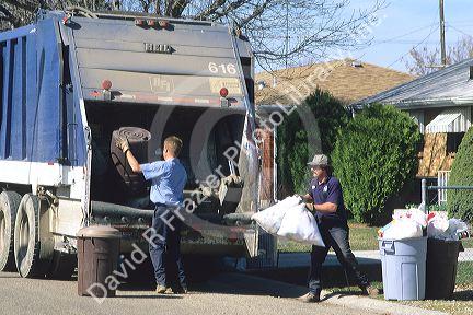 Garbage collectors haul trash from garbage cans.
