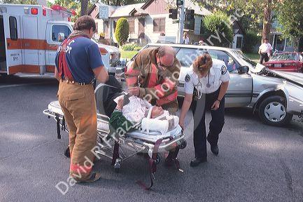 Paramedics and firemen at a car accident scene.
