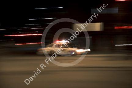 Police car in motion at night with lights flashing in Boise, Idaho.